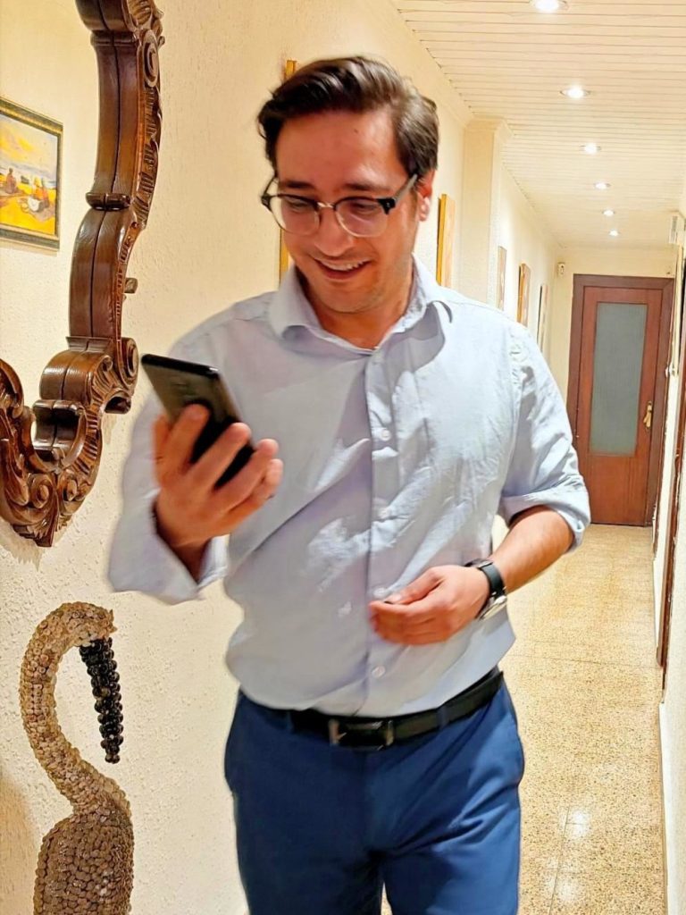 Gabriel Rodríguez Sáiz Gabriel Rodríguez Sáiz mirando el móvil con un pasillo de fondo.
